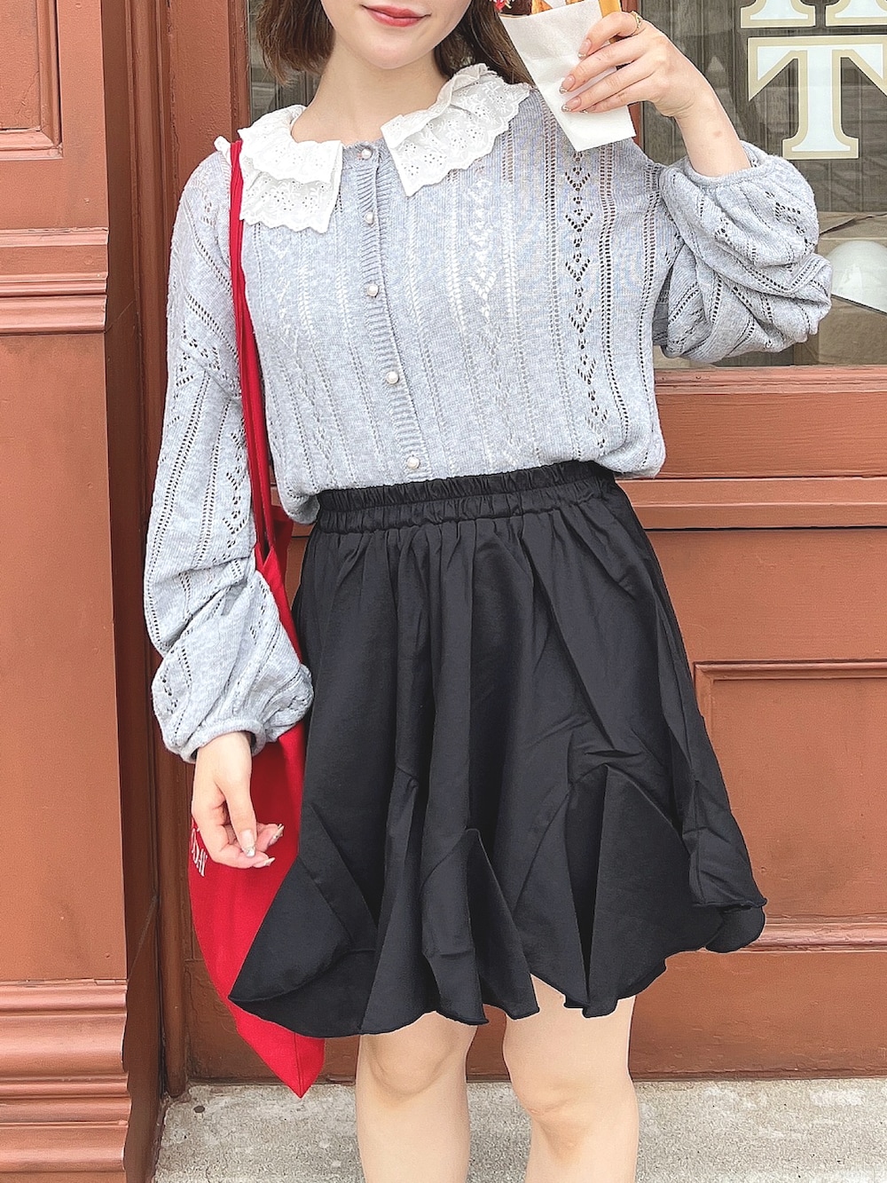 ブラック系のスカート、ホワイト系のスカート、レッド系のカーディガン/ボレロを着用したレディースの春コーディネートの4枚目の写真