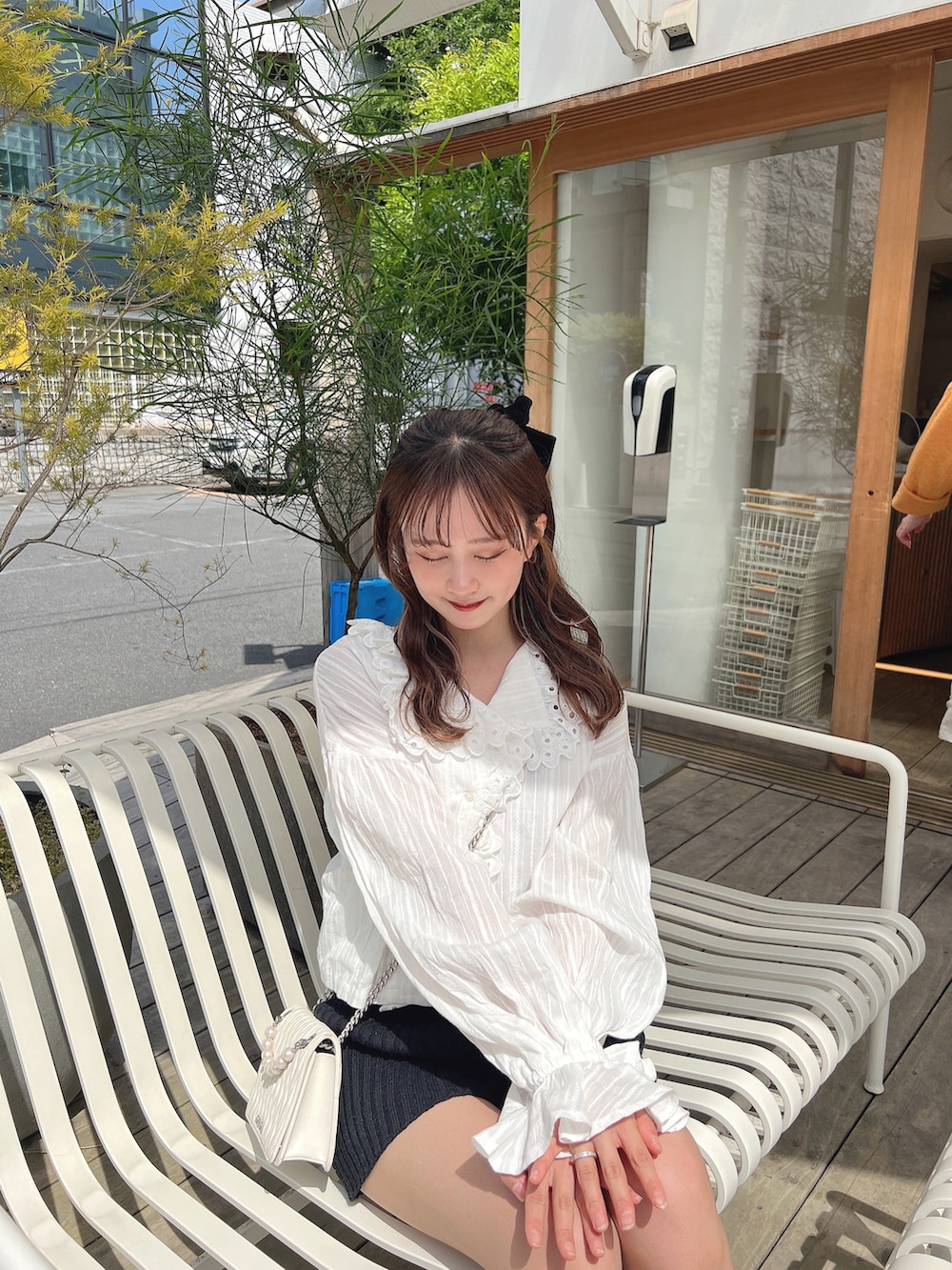 ホワイト系のシャツ/ブラウス、ブラック系のパンツを着用したレディースの春コーディネートの3枚目の写真