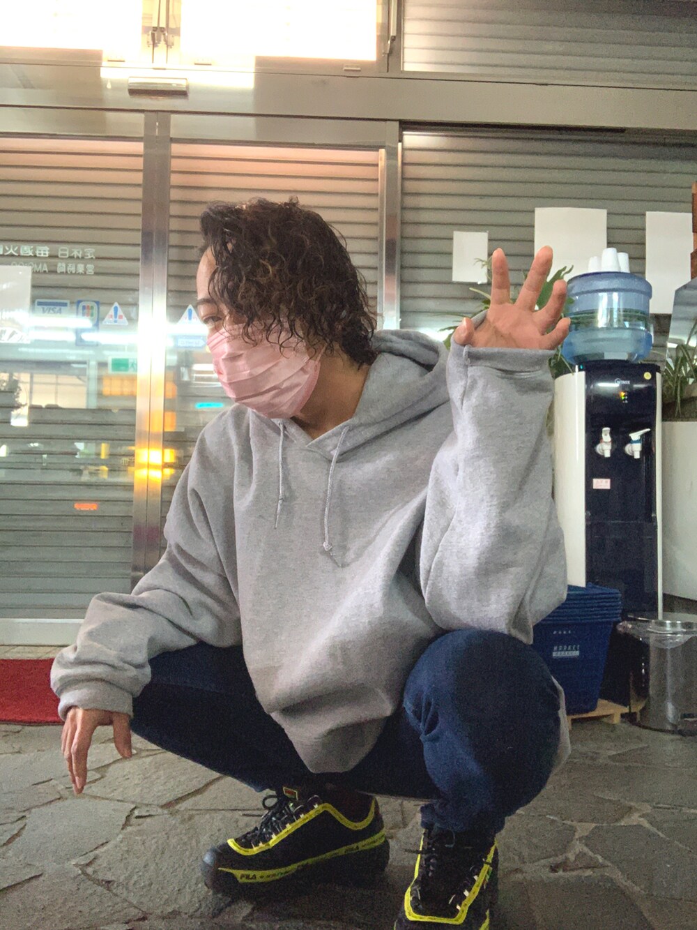 グレー系のパーカー、ブルー系のデニムパンツ、ブラック系のスニーカーを着用したメンズの冬コーディネートの2枚目の写真