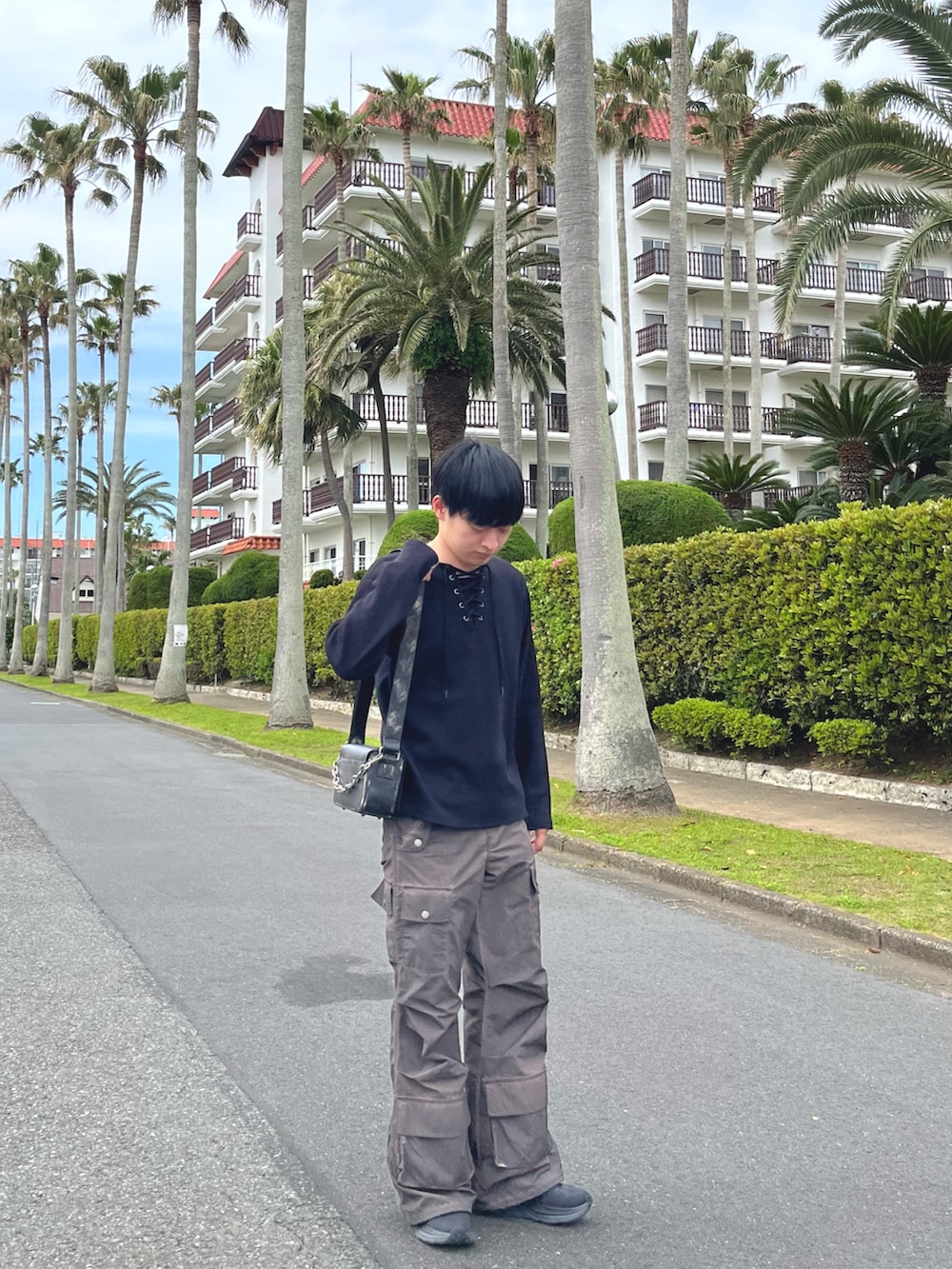 ブラック系のTシャツ/カットソー、ブラウン系のカーゴパンツ、ブラック系のショルダーバッグを着用したメンズの春コーディネートの2枚目の写真