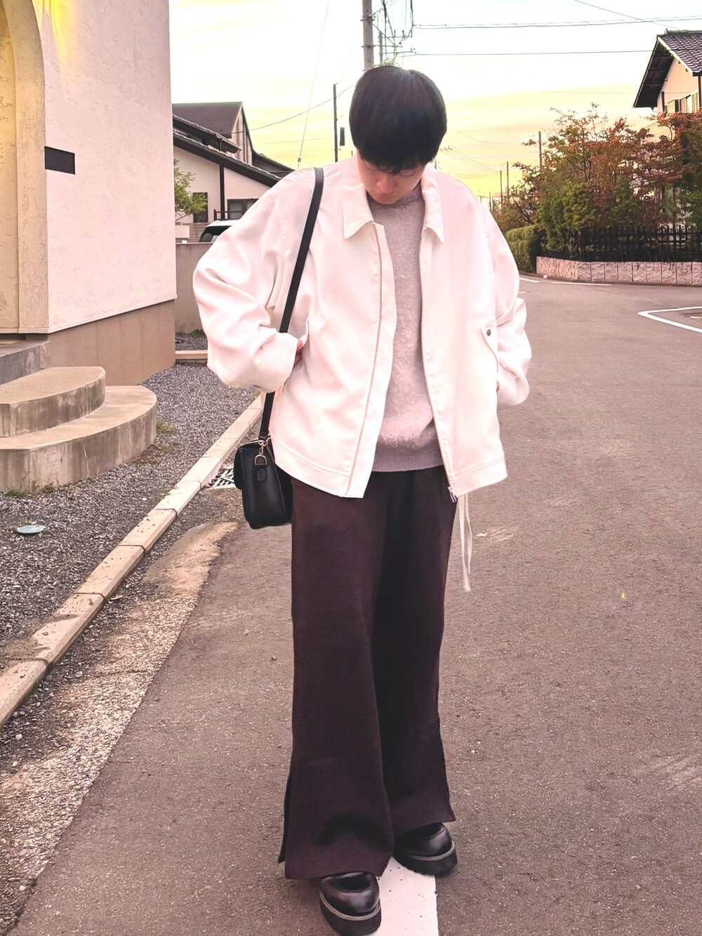 ブラック系のスウェットパンツ、ブラック系のドレスシューズ、ホワイト系のブルゾンを着用したメンズの秋コーディネートの2枚目の写真