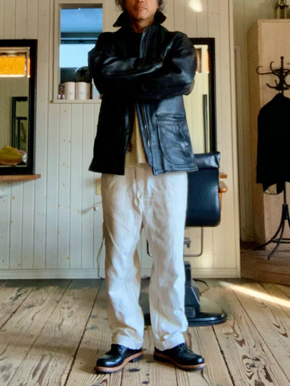 ブラック系のライダースジャケット、ホワイト系のデニムパンツを着用したメンズの春コーディネートの2枚目の写真