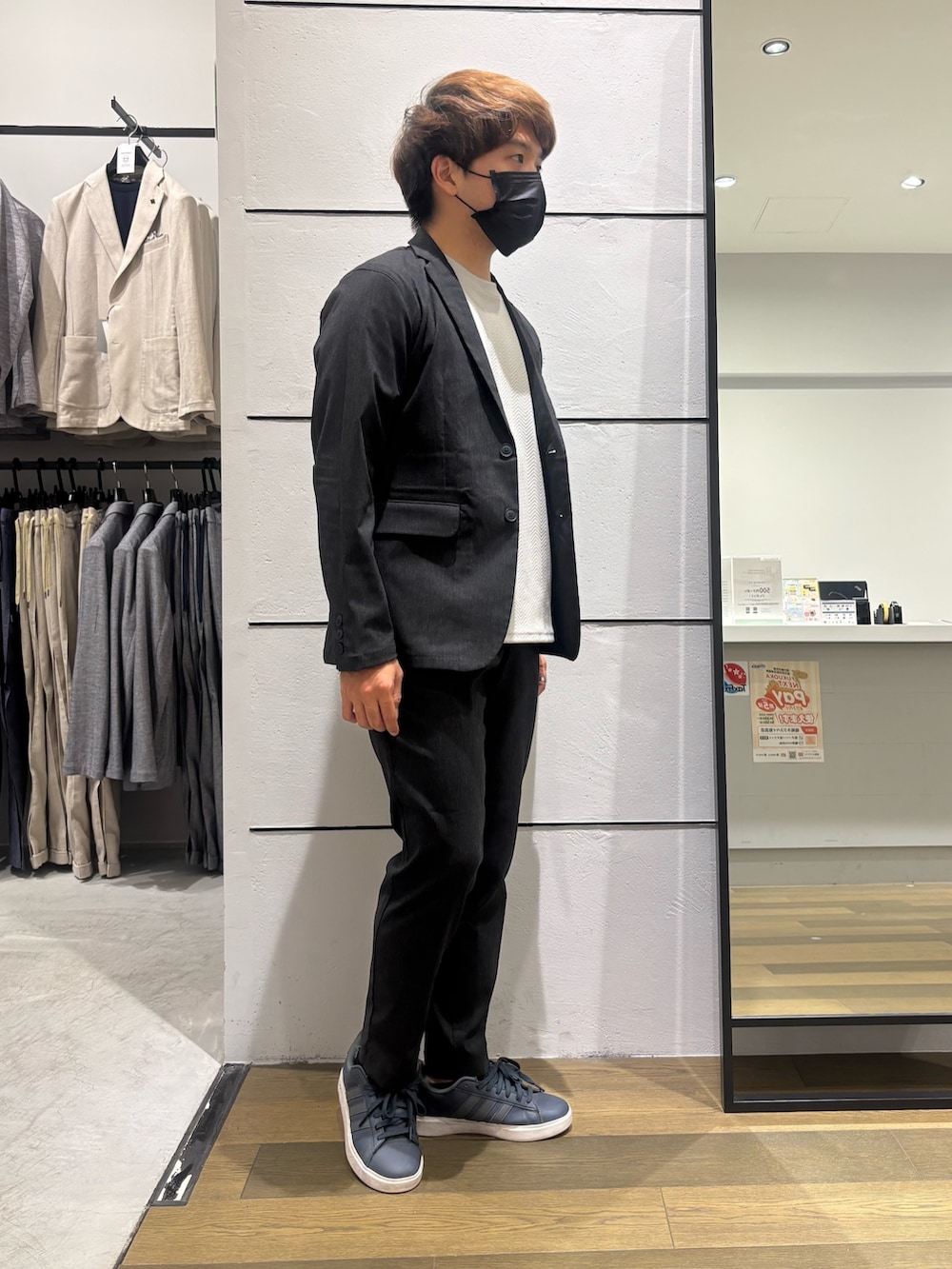 ブラック系のテーラードジャケット、ベージュ系のTシャツ/カットソー、ブラック系のスラックスを着用したメンズの春コーディネートの3枚目の写真