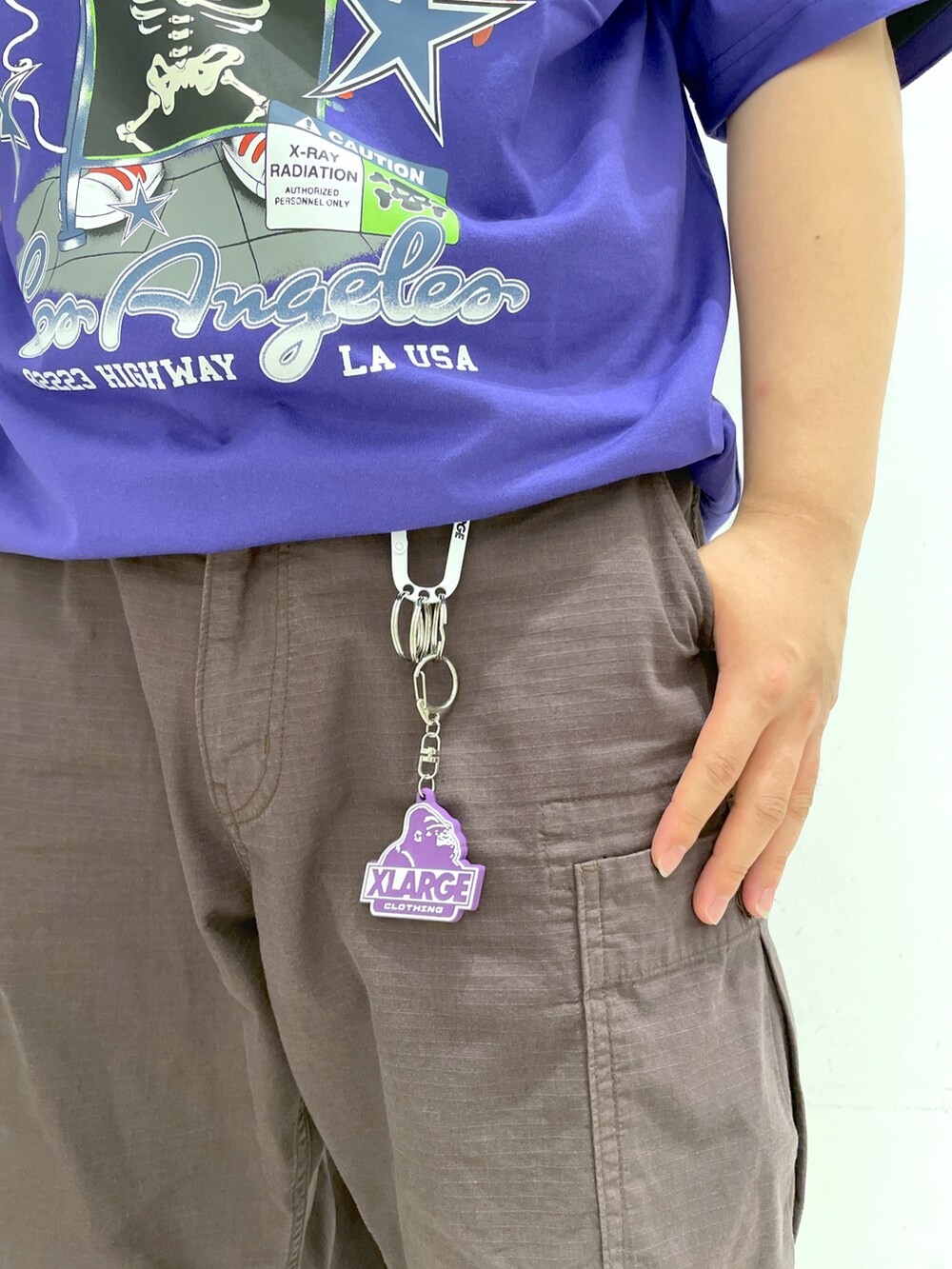 パープル系のTシャツ/カットソー、ブラウン系のカーゴパンツ、ブラウン系のサングラスを着用したメンズの夏コーディネートの4枚目の写真