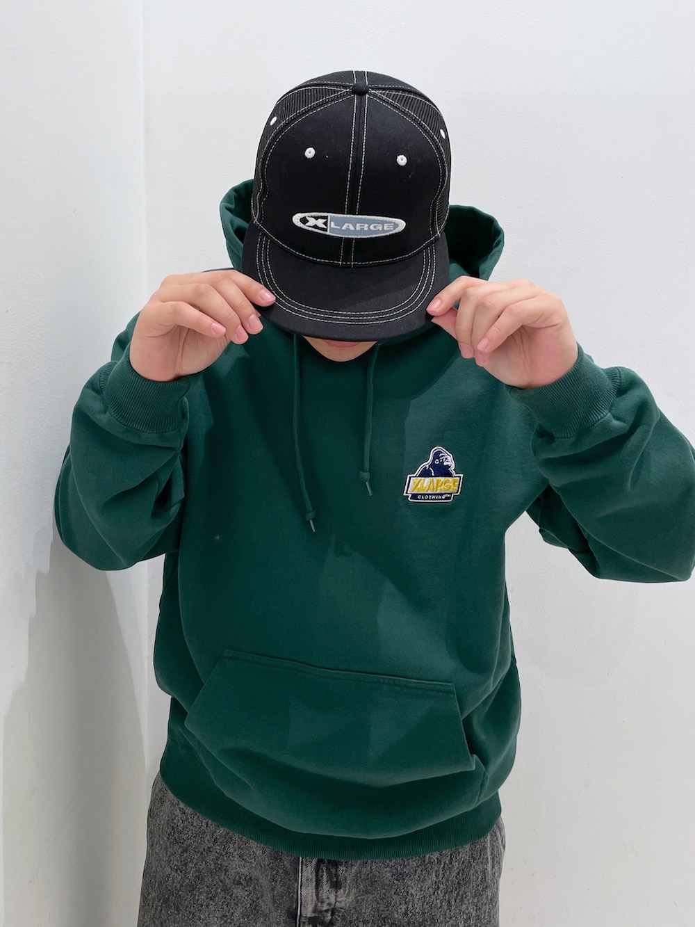 グリーン系のパーカー、ブラック系のその他パンツ、ブラック系のキャップを着用したメンズの冬コーディネートの5枚目の写真