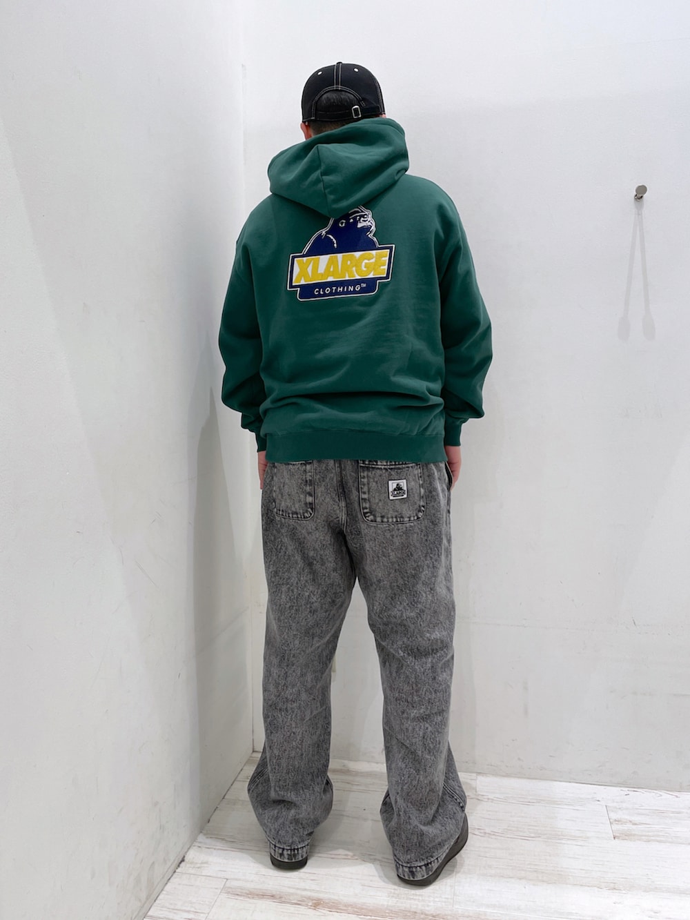 グリーン系のパーカー、ブラック系のその他パンツ、ブラック系のキャップを着用したメンズの冬コーディネートの3枚目の写真