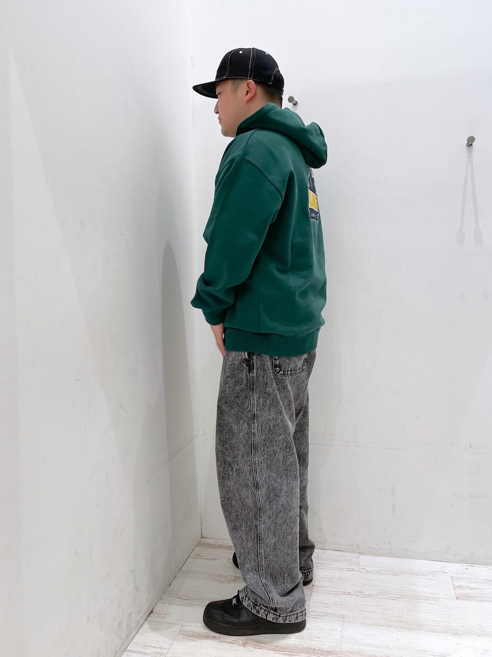 グリーン系のパーカー、ブラック系のその他パンツ、ブラック系のキャップを着用したメンズの冬コーディネートの2枚目の写真