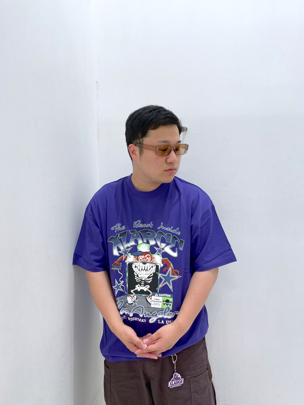 パープル系のTシャツ/カットソー、ブラウン系のカーゴパンツ、ブラウン系のサングラスを着用したメンズの夏コーディネートの5枚目の写真