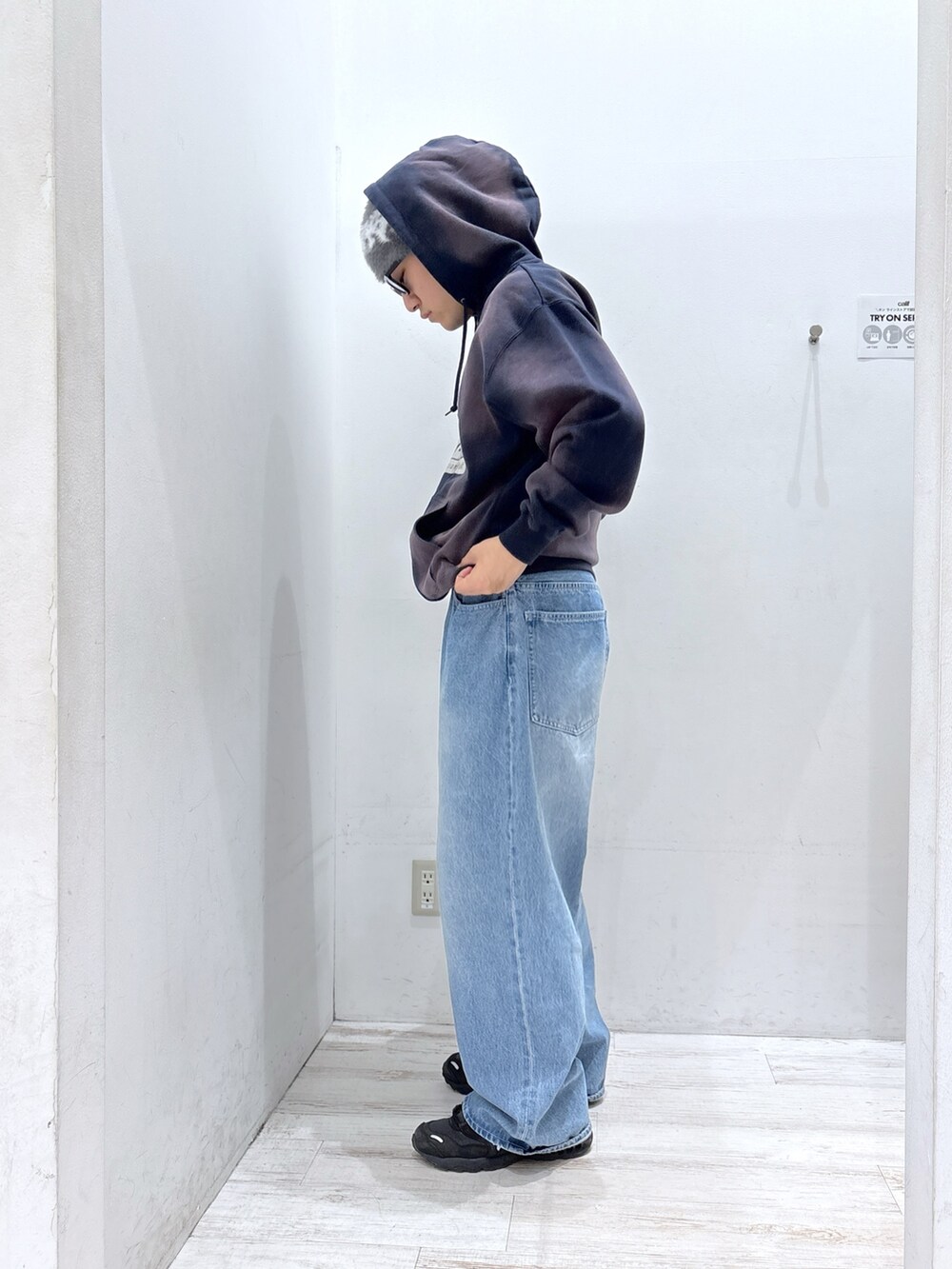 ブルー系のパーカー、ブルー系のデニムパンツ、ブラック系のサングラスを着用したメンズの秋コーディネートの2枚目の写真