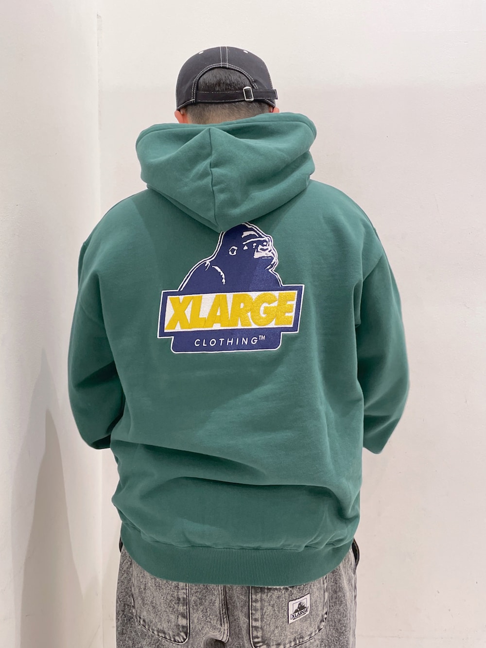 グリーン系のパーカー、ブラック系のその他パンツ、ブラック系のキャップを着用したメンズの冬コーディネートの4枚目の写真