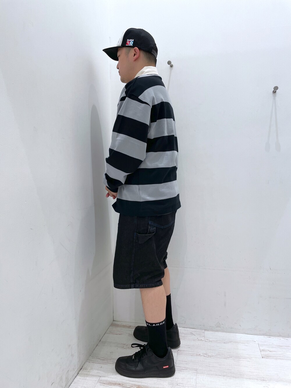 ブラック系のポロシャツ、ブラック系のキャップを着用したメンズの春コーディネートの3枚目の写真