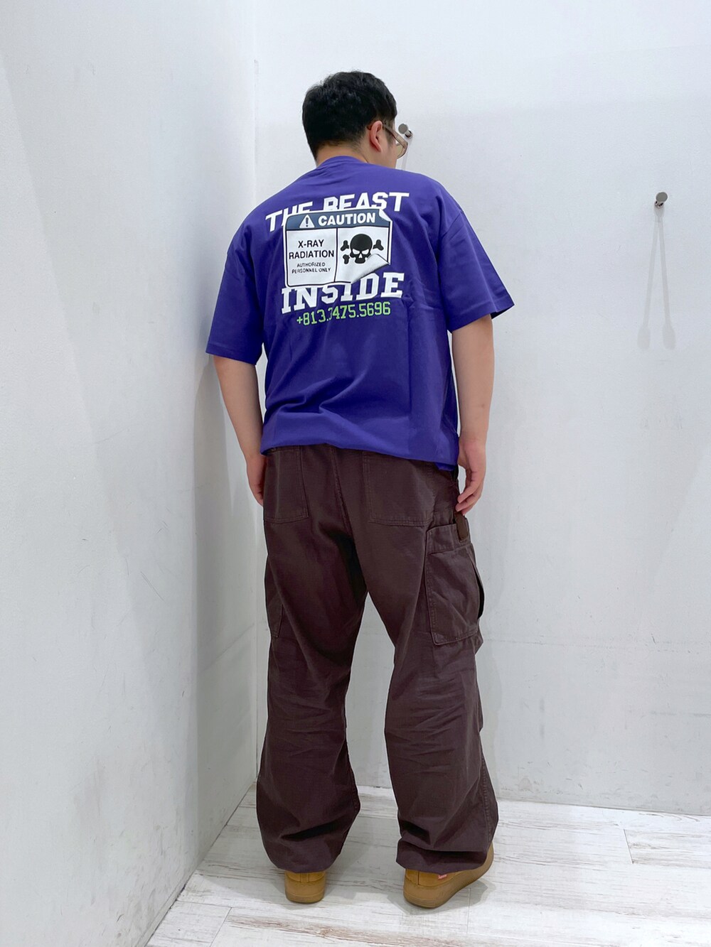 パープル系のTシャツ/カットソー、ブラウン系のカーゴパンツ、ブラウン系のサングラスを着用したメンズの夏コーディネートの3枚目の写真