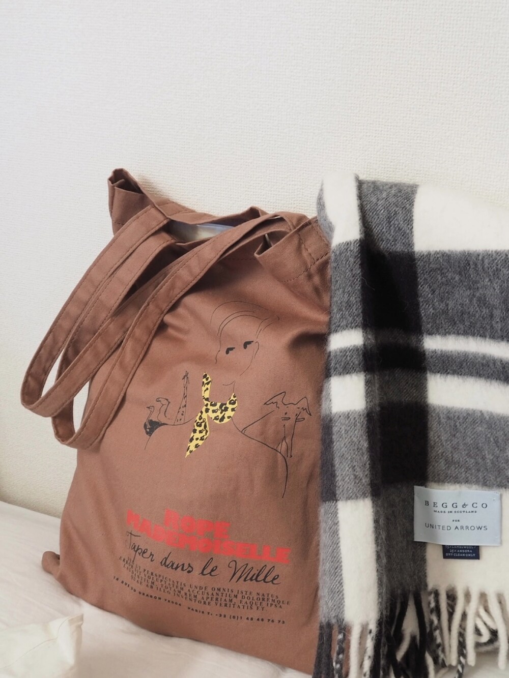 イエロー系のニット/セーター、ホワイト系のその他パンツ、ブラウン系のトートバッグを着用したレディースの冬コーディネートの2枚目の写真