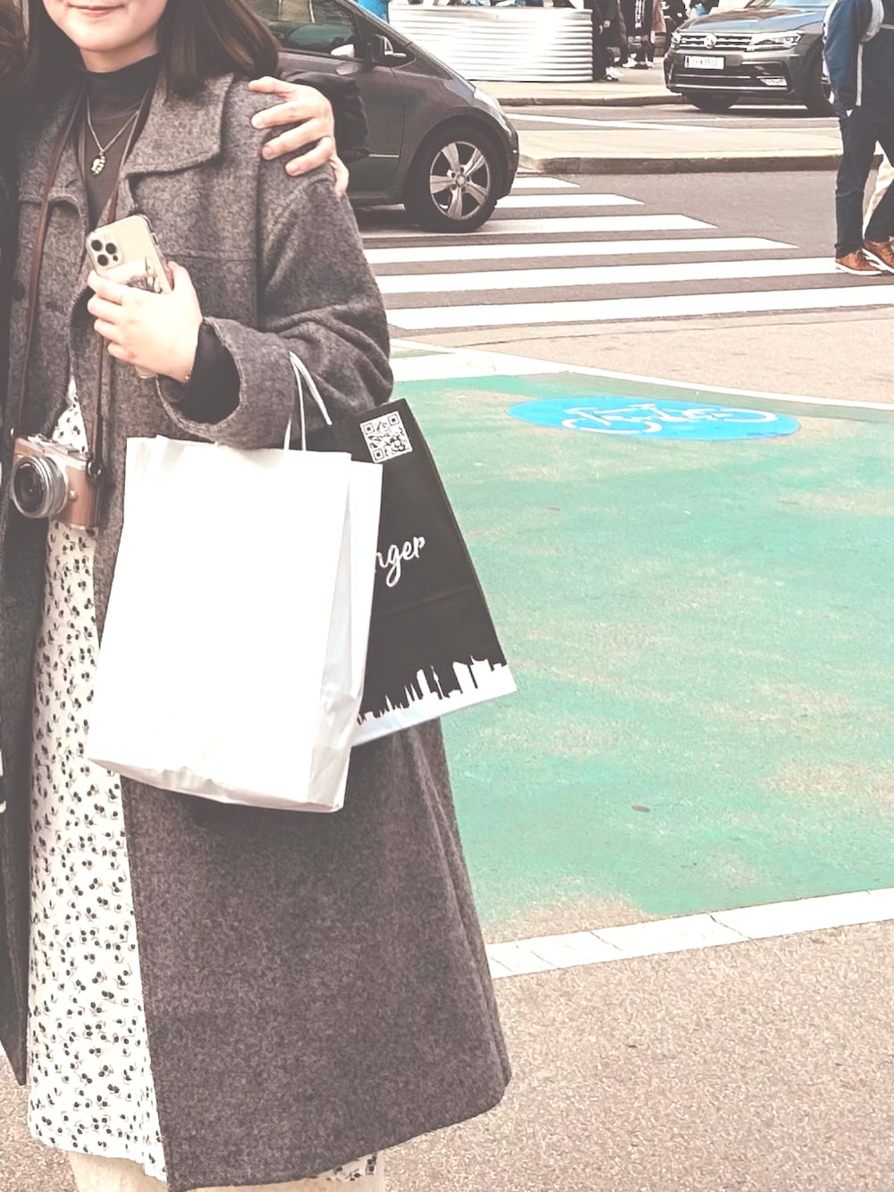 ブラック系のワンピース、グレー系のステンカラーコート、ホワイト系のその他パンツを着用したレディースの冬コーディネートの2枚目の写真