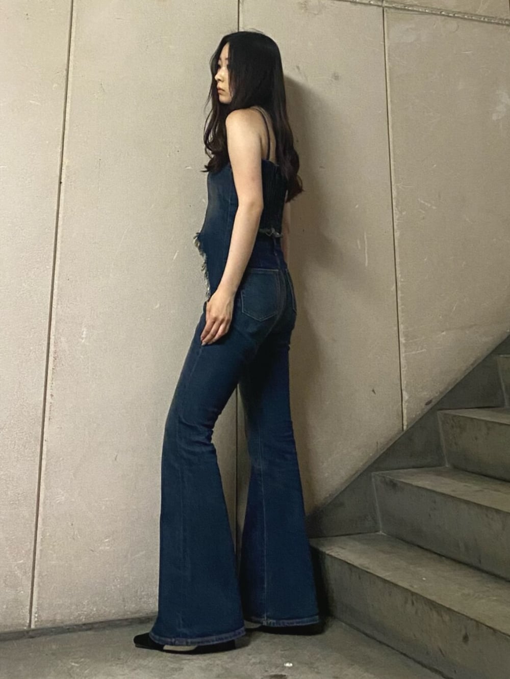 ブルー系のキャミソール、ブルー系のデニムパンツ、ブラック系のパンプスを着用したレディースの夏コーディネートの2枚目の写真