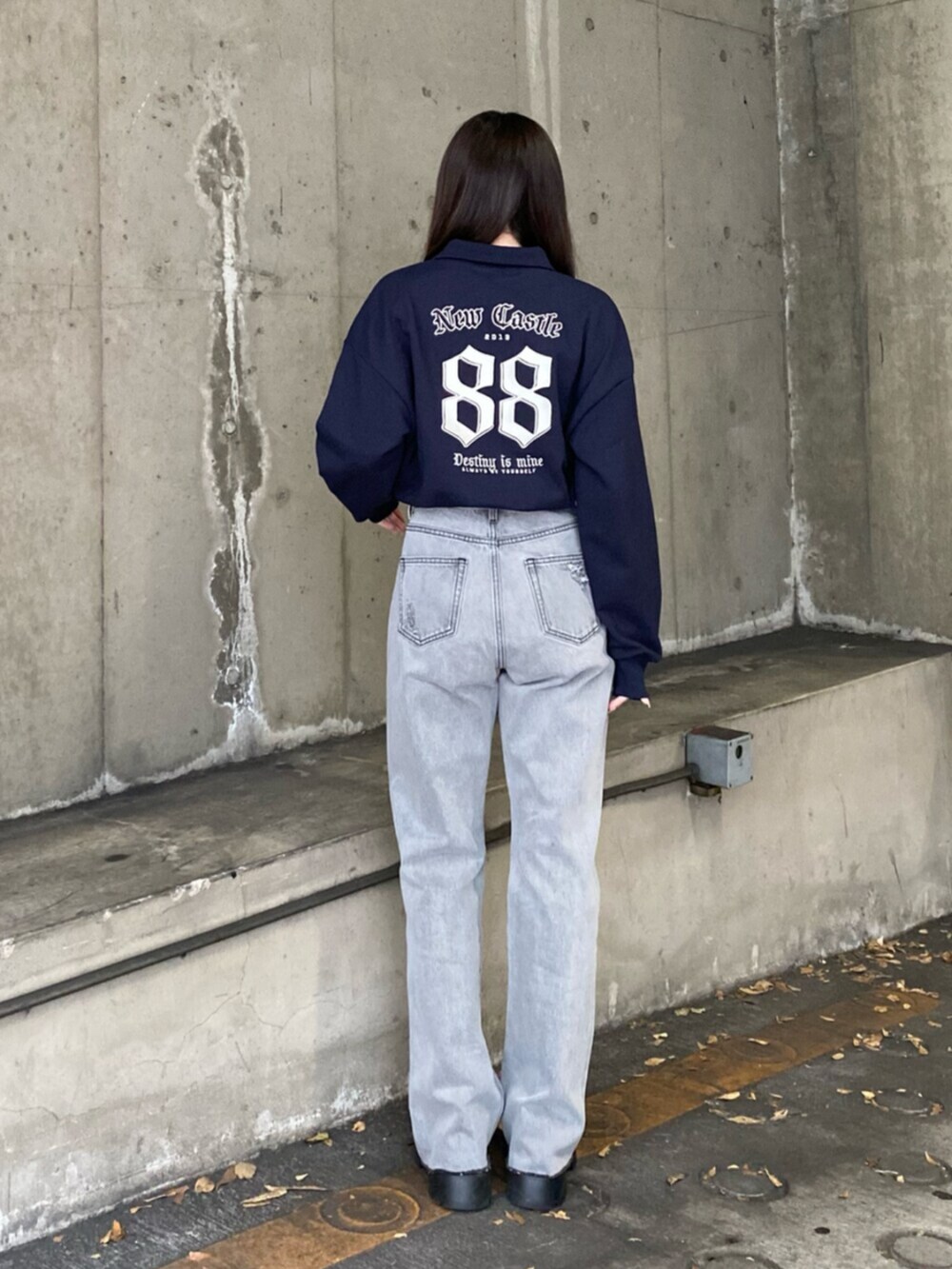 ブラック系のデニムパンツ、ブルー系のスウェット、ブラック系のブーツを着用したレディースの冬コーディネートの3枚目の写真
