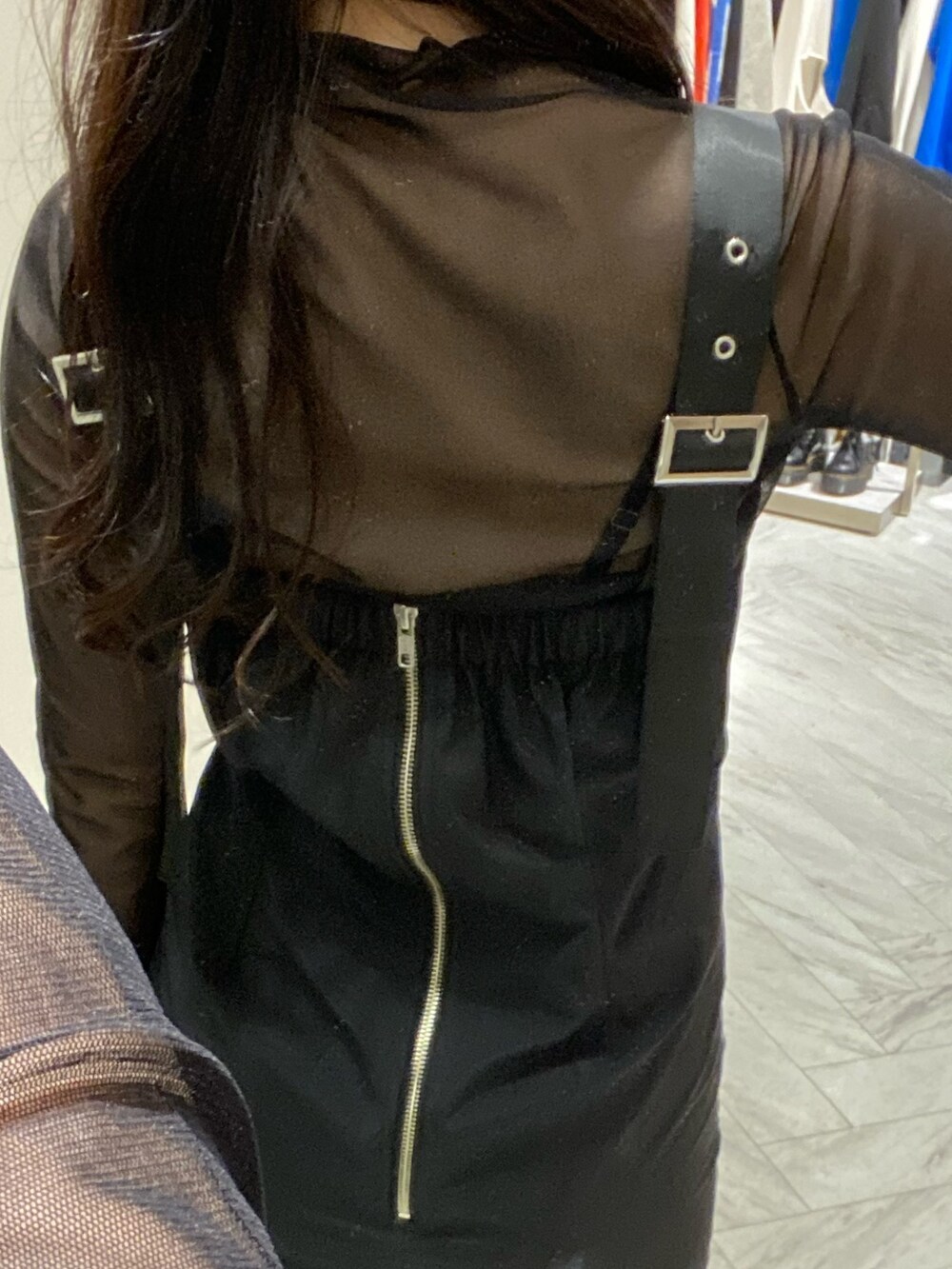 ブラック系のブーツ、ホワイト系のショルダーバッグ、ブラック系のワンピースを着用したレディースの冬コーディネートの3枚目の写真