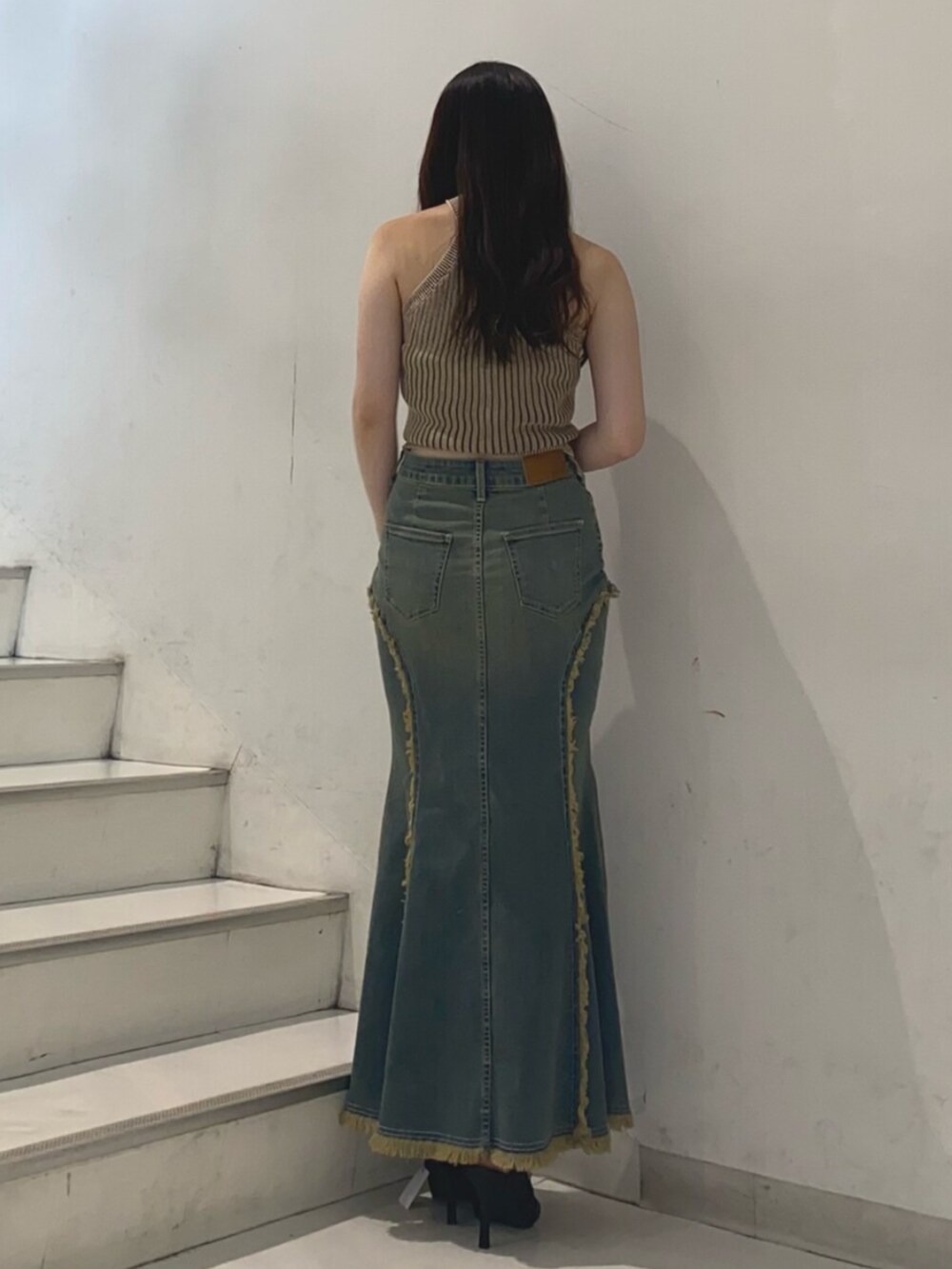 ブラック系のサンダル、ブルー系のデニムスカート、ブラウン系のニット/セーターを着用したレディースの夏コーディネートの3枚目の写真