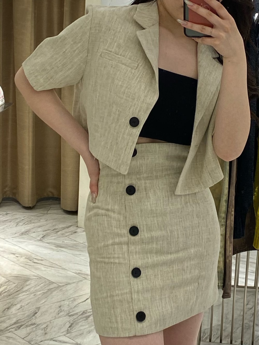 ホワイト系のテーラードジャケット、ホワイト系のスカート、ブラック系のサンダルを着用したレディースの春コーディネートの3枚目の写真