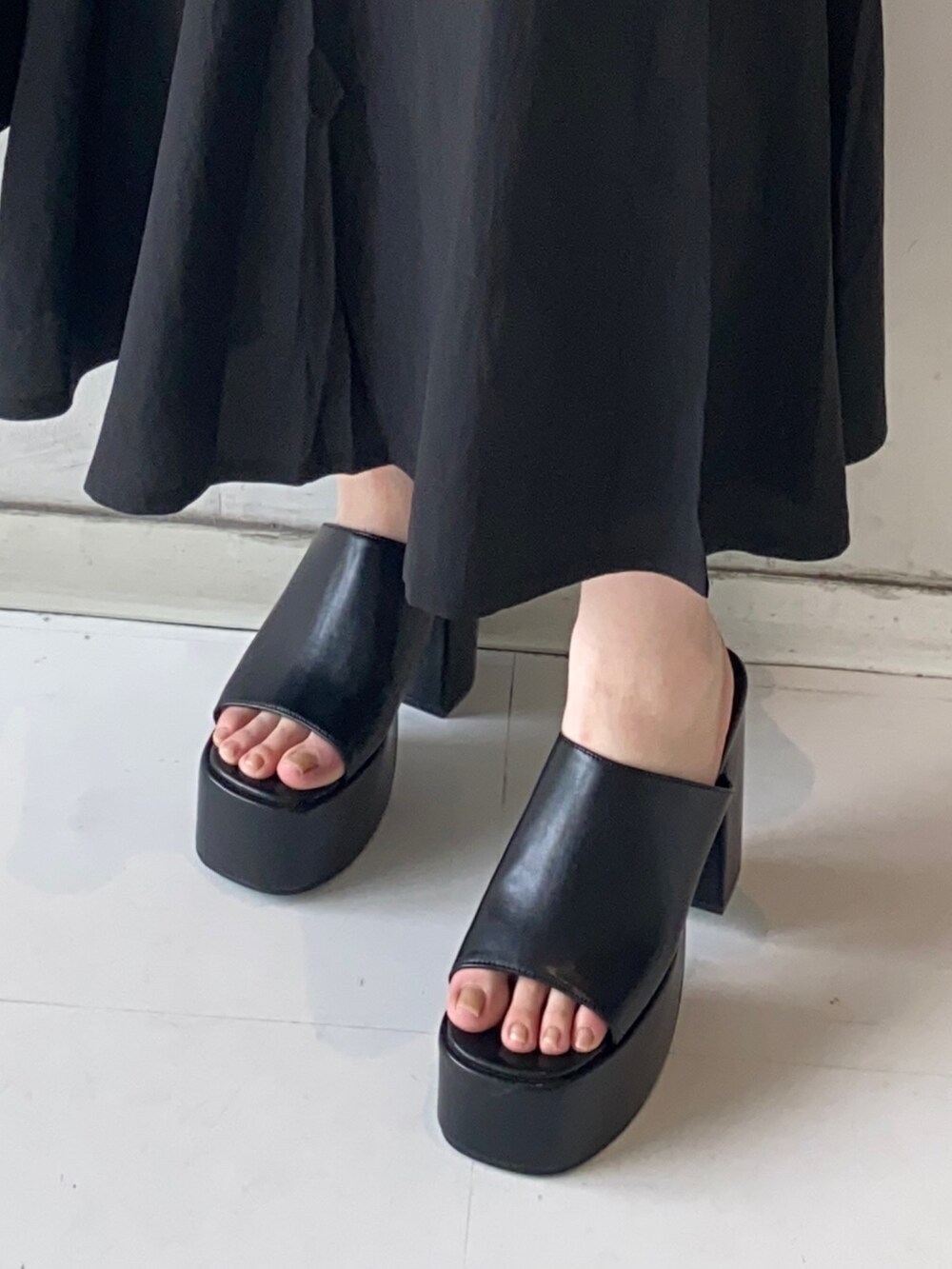 ブラック系のワンピース、ブラック系のサンダル、ブラック系のハンドバッグを着用したレディースの夏コーディネートの7枚目の写真