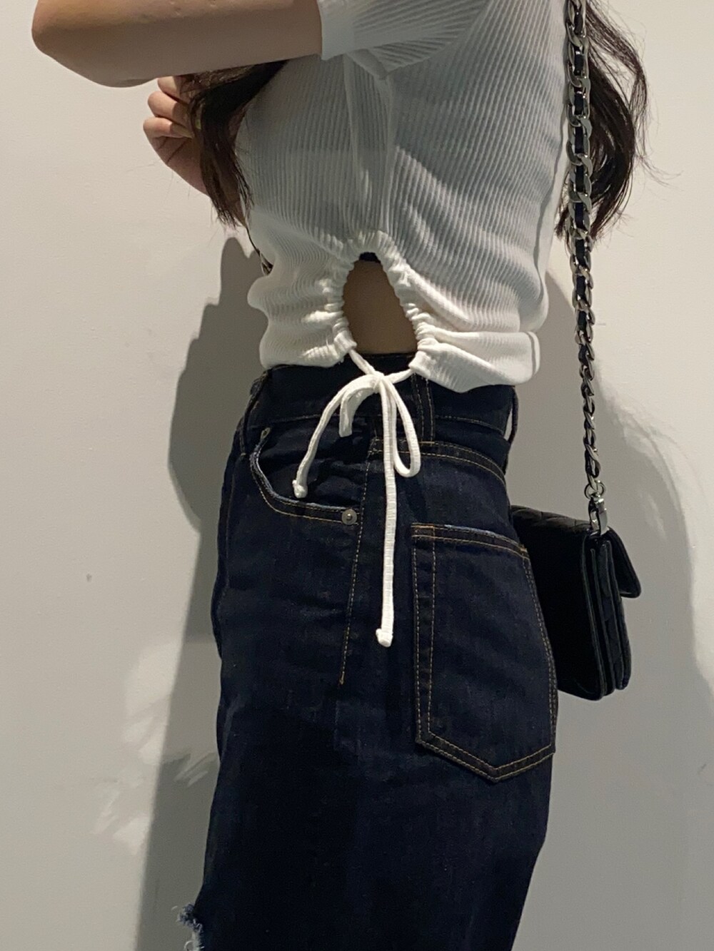 ホワイト系のTシャツ/カットソー、ブラック系のショルダーバッグ、ブルー系のデニムパンツを着用したレディースの夏コーディネートの4枚目の写真