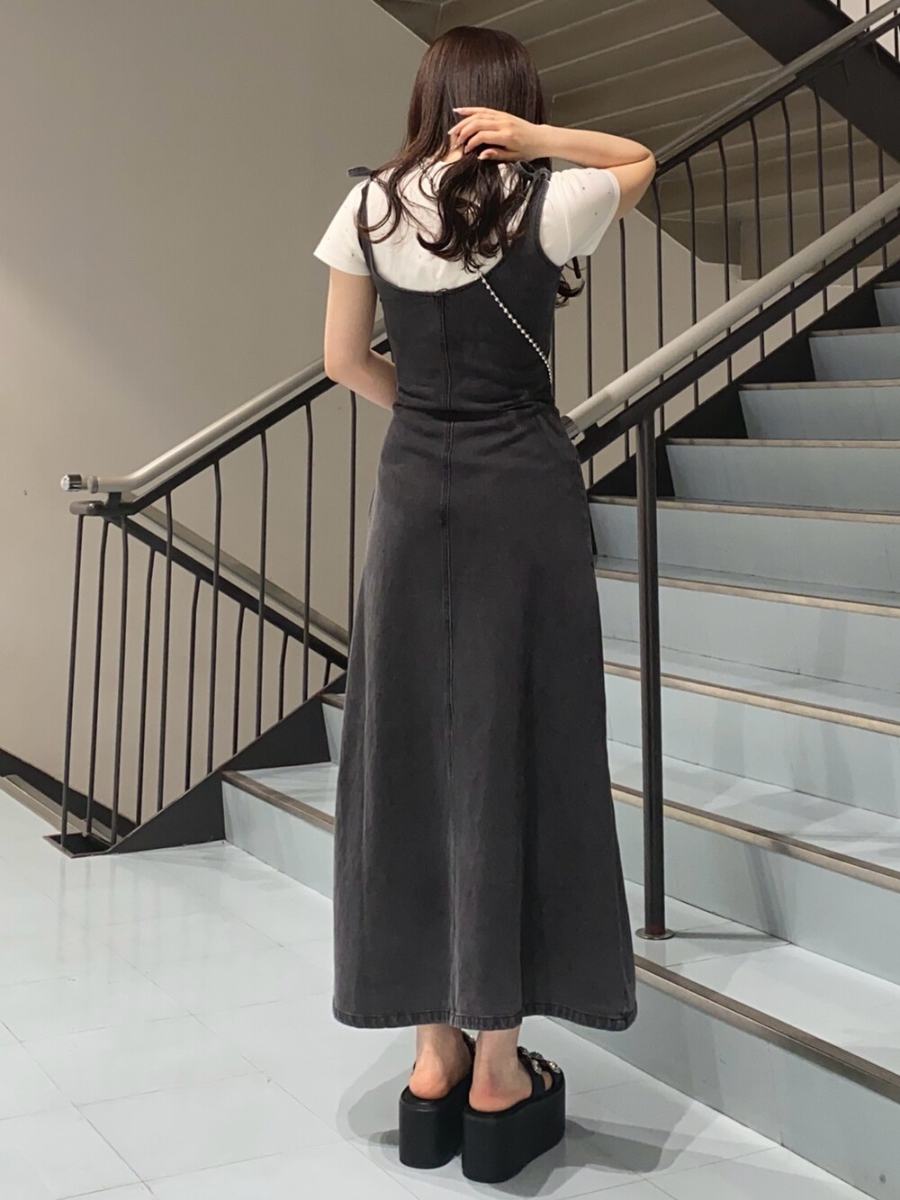 ブラック系のサンダル、ブラック系のワンピース、ホワイト系のTシャツ/カットソーを着用したレディースの夏コーディネートの3枚目の写真