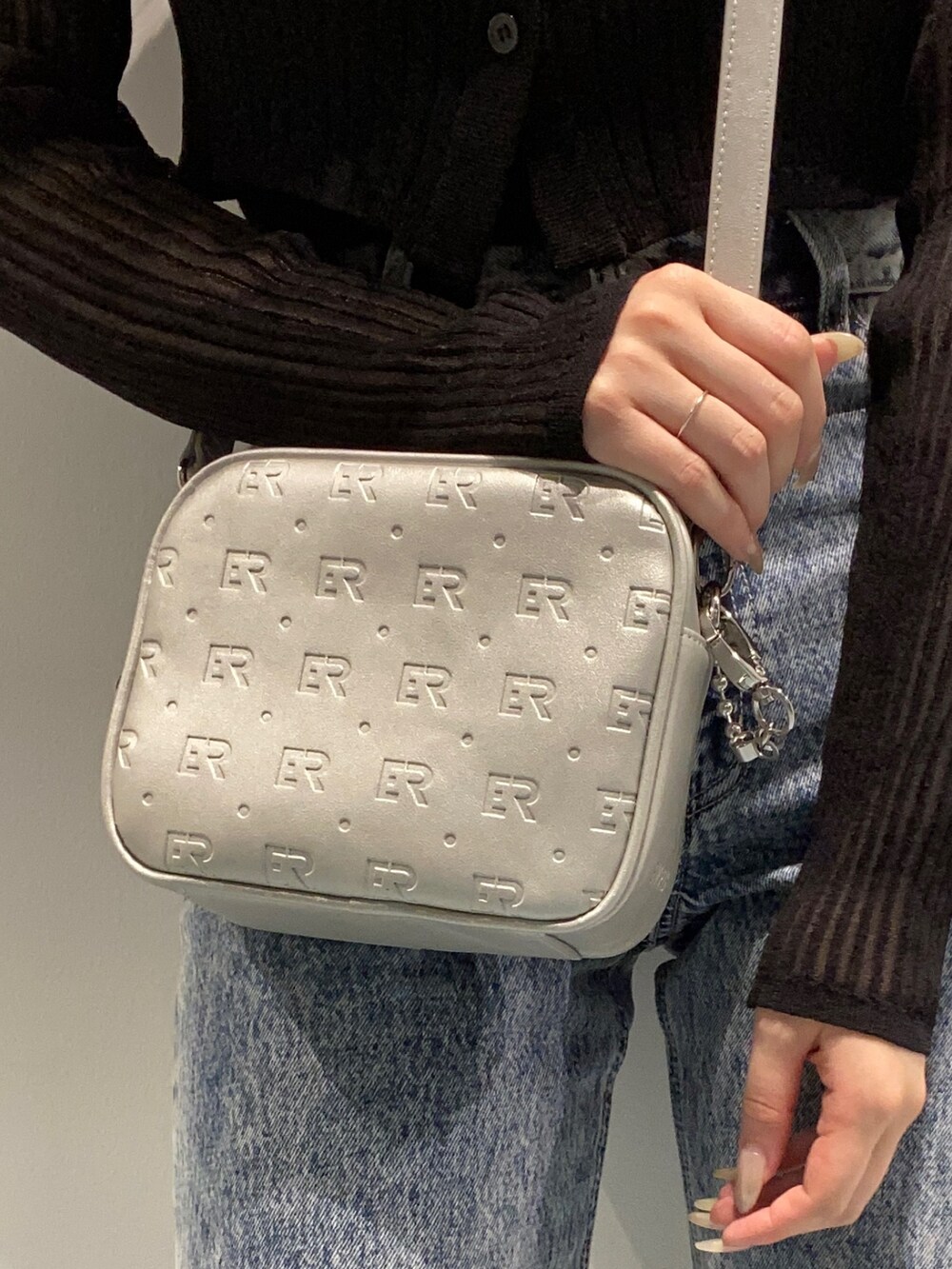 ブラック系のカーディガン/ボレロ、ブルー系のデニムパンツ、ブラック系のサンダルを着用したレディースの春コーディネートの6枚目の写真