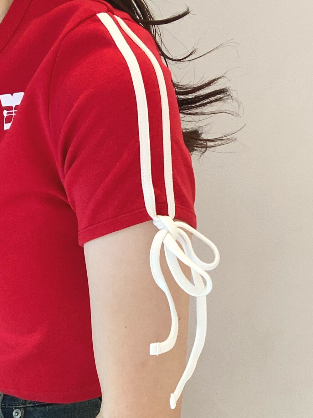 レッド系のTシャツ/カットソー、ブルー系のデニムパンツ、ホワイト系のサンダルを着用したレディースの夏コーディネートの4枚目の写真