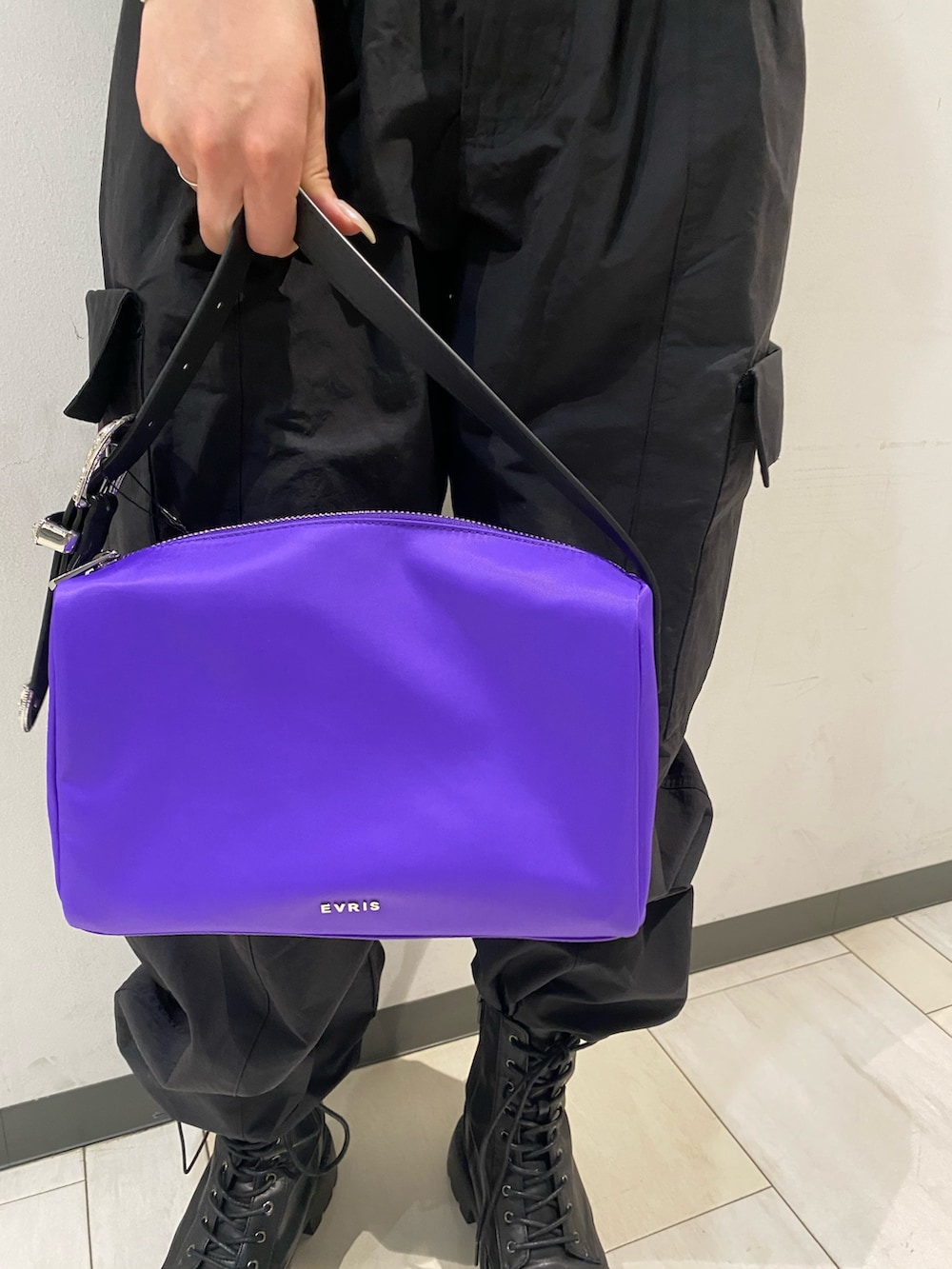 ブラック系のTシャツ/カットソー、パープル系のハンドバッグ、ブラック系のブーツを着用したレディースの春コーディネートの6枚目の写真