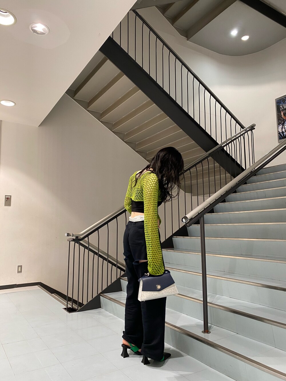 グリーン系のニット/セーター、ブラック系のサンダル、シルバー系のショルダーバッグを着用したレディースの春コーディネートの3枚目の写真