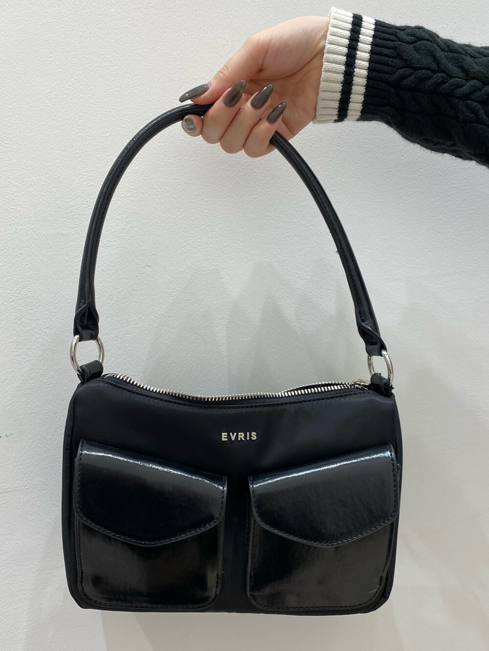 ブラック系のニット/セーター、ホワイト系のスウェットパンツ、ブラック系のハンドバッグを着用したレディースの秋コーディネートの6枚目の写真