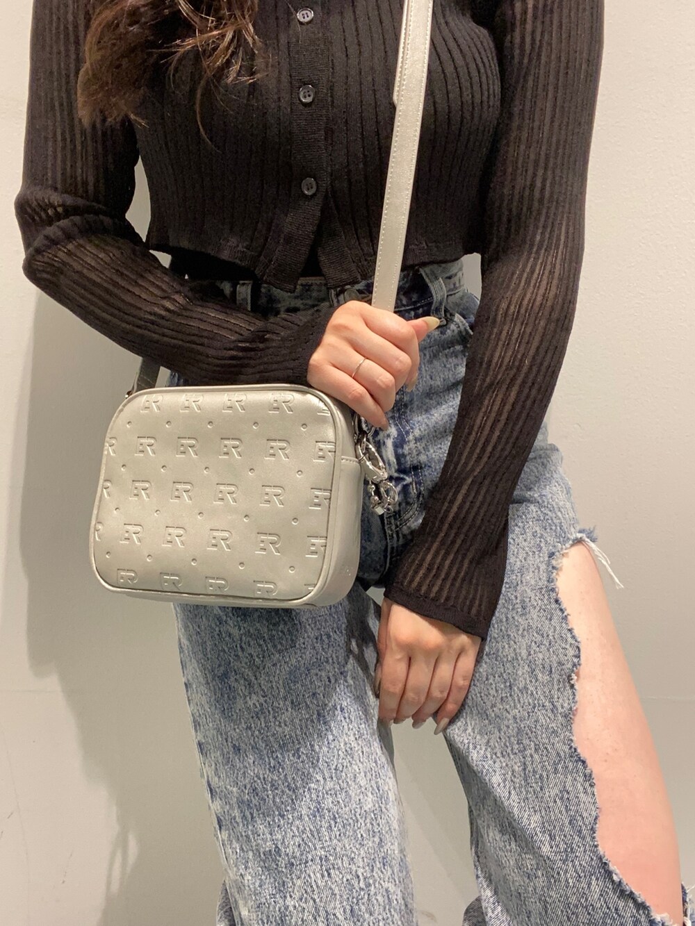 ブラック系のカーディガン/ボレロ、ブルー系のデニムパンツ、ブラック系のサンダルを着用したレディースの春コーディネートの5枚目の写真