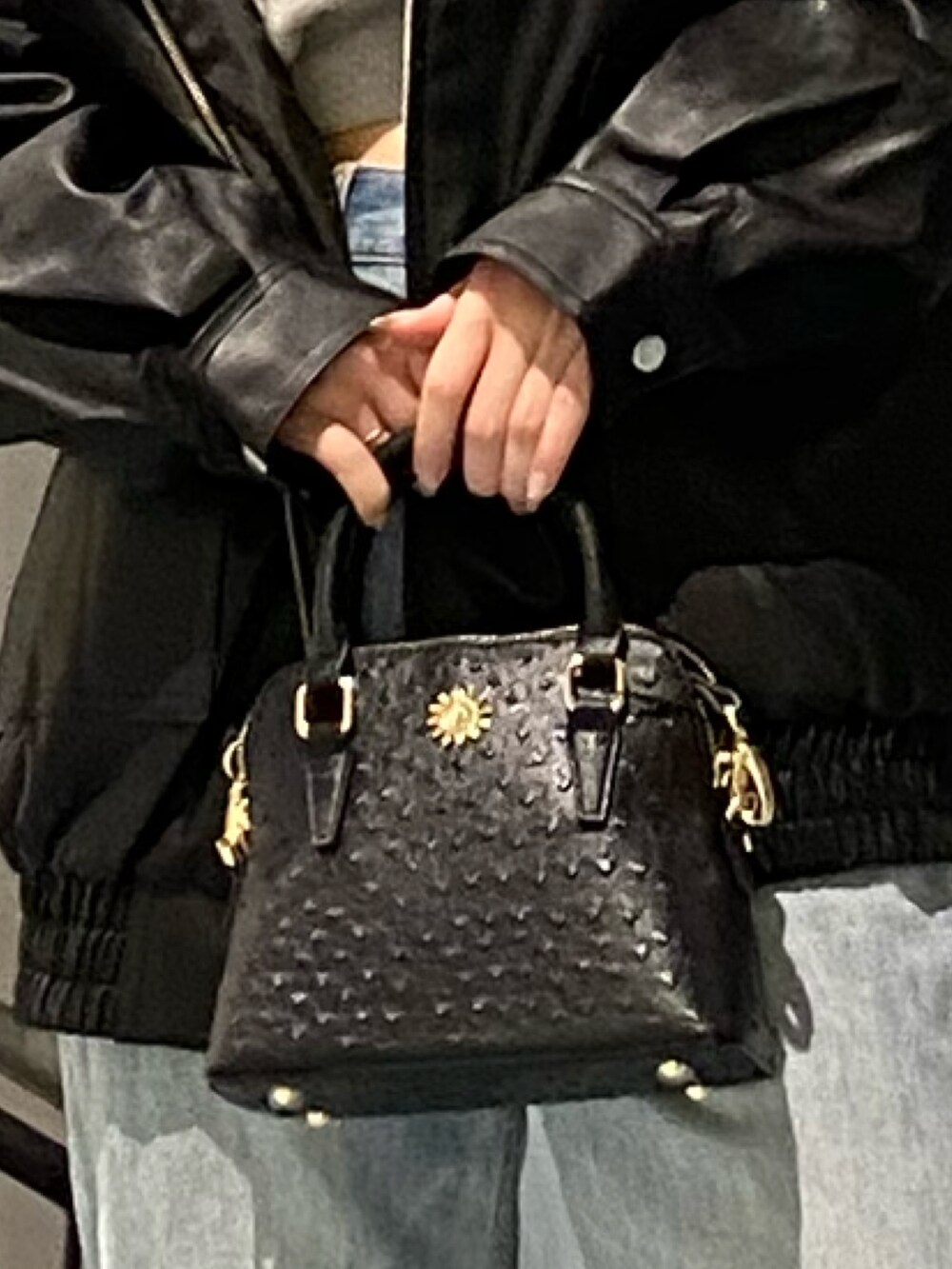 ブラック系のブルゾン、ブラック系のブーツ、ブルー系のデニムパンツを着用したレディースの秋コーディネートの7枚目の写真