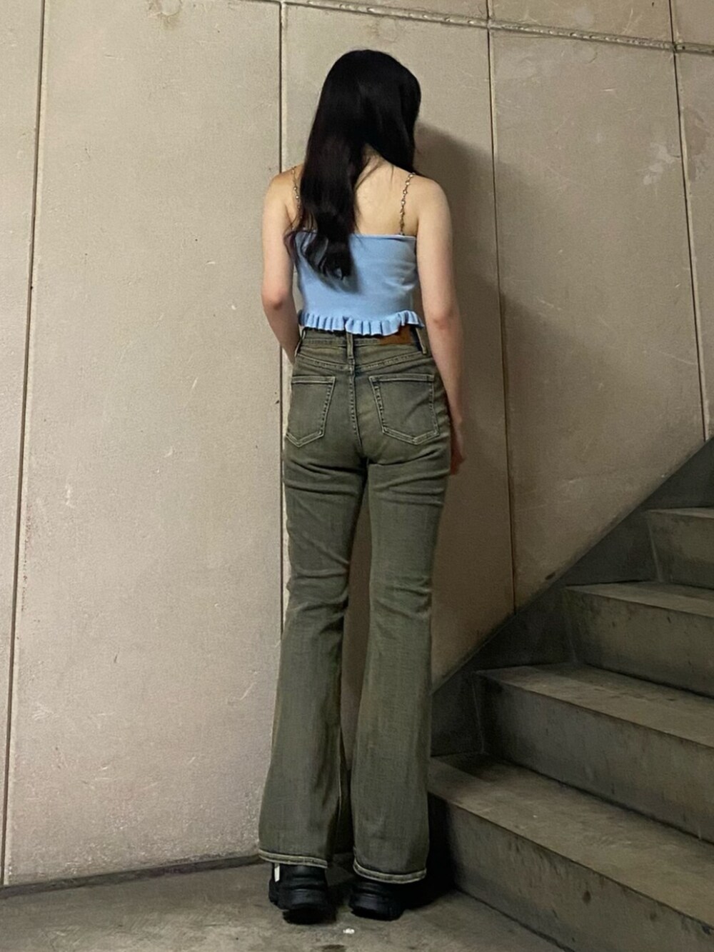 ブルー系のキャミソール、ブルー系のデニムパンツ、ブラック系のサンダルを着用したレディースの夏コーディネートの3枚目の写真