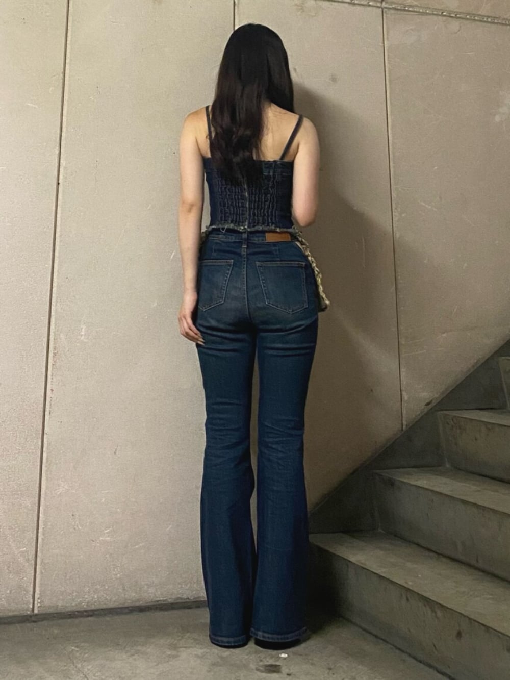 ブルー系のキャミソール、ブルー系のデニムパンツ、ブラック系のパンプスを着用したレディースの夏コーディネートの3枚目の写真