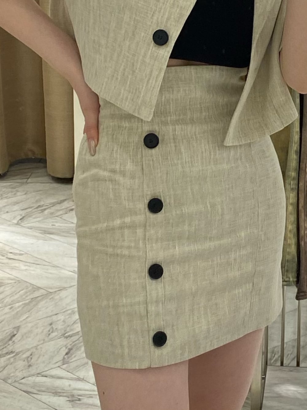 ホワイト系のテーラードジャケット、ホワイト系のスカート、ブラック系のサンダルを着用したレディースの春コーディネートの5枚目の写真