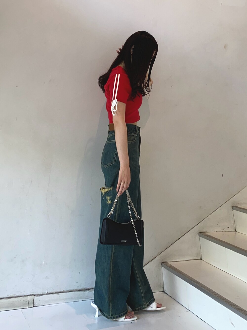 レッド系のTシャツ/カットソー、ブルー系のデニムパンツ、ホワイト系のサンダルを着用したレディースの夏コーディネートの2枚目の写真