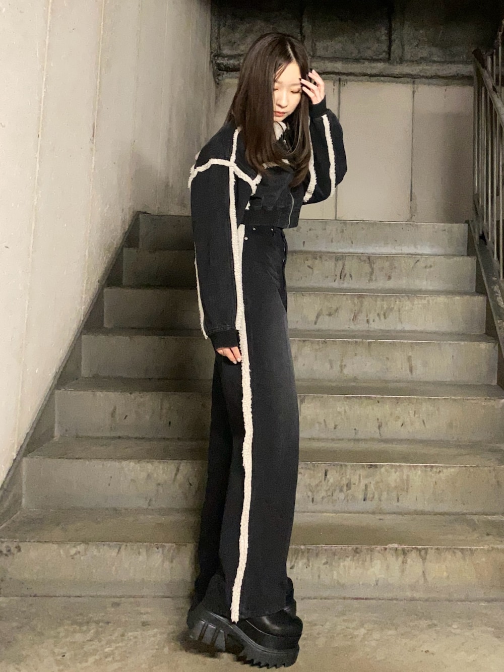 ブラック系のブルゾン、ブラック系のデニムパンツ、ブラック系のブーツを着用したレディースの秋コーディネートの2枚目の写真