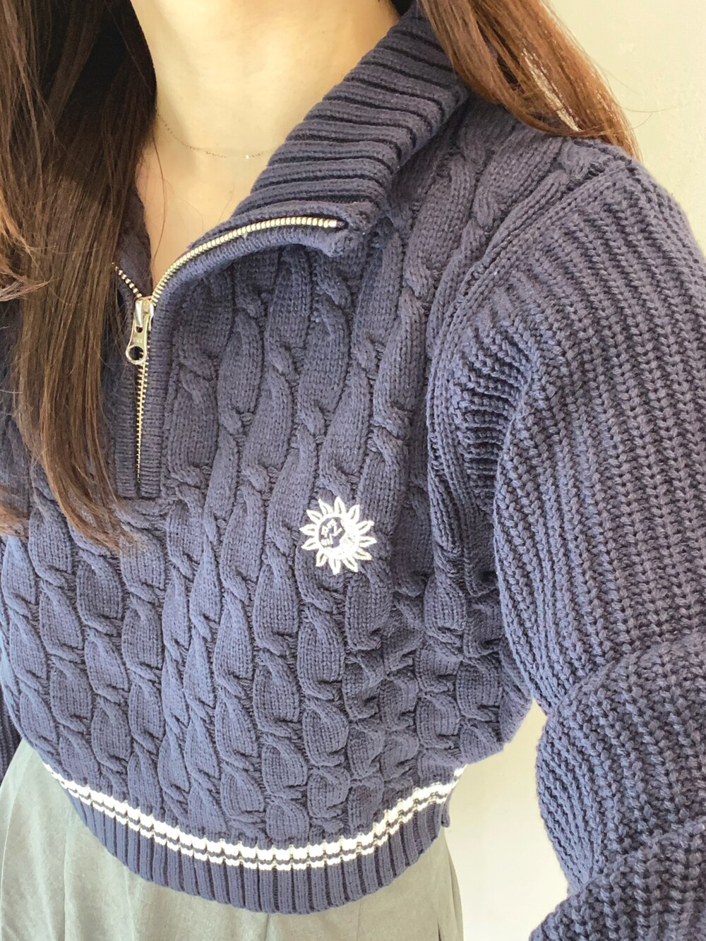 グレー系のスカート、ブルー系のニット/セーター、ブラック系のショルダーバッグを着用したレディースの夏コーディネートの4枚目の写真