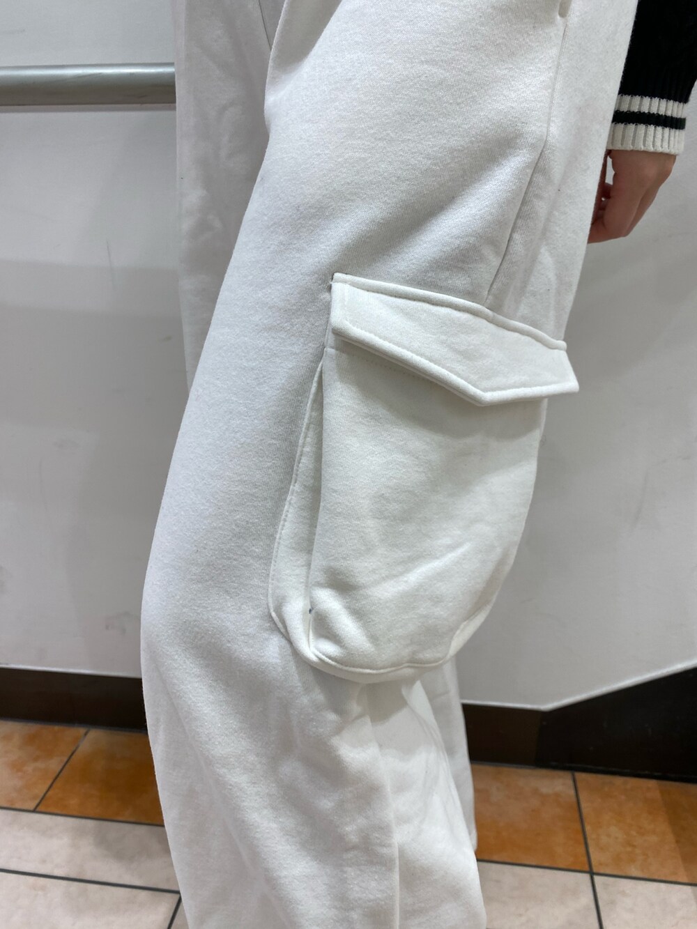 ブラック系のニット/セーター、ホワイト系のスウェットパンツ、ブラック系のハンドバッグを着用したレディースの秋コーディネートの4枚目の写真