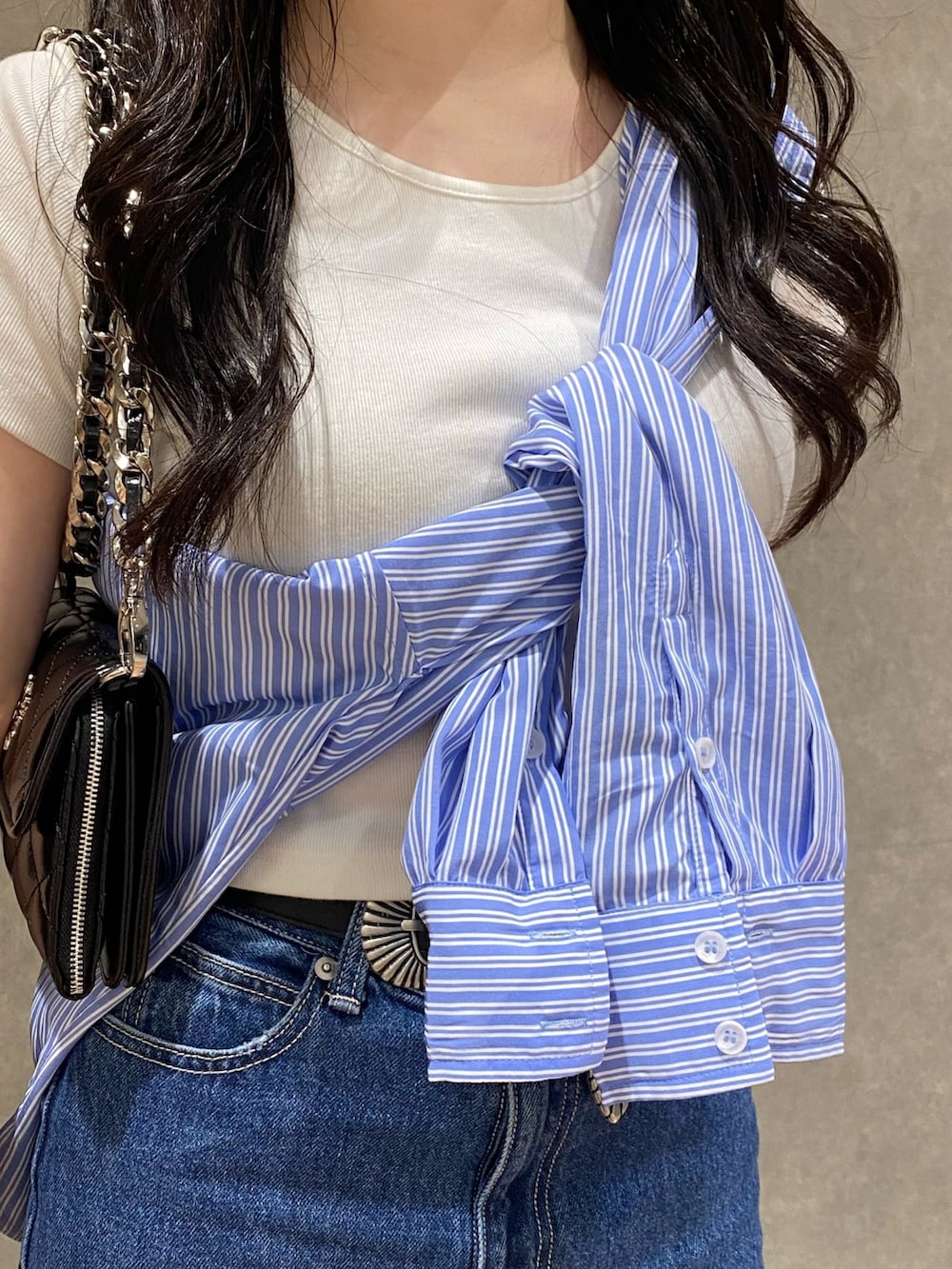 ブラック系のスニーカー、ブルー系のシャツ/ブラウス、ホワイト系のTシャツ/カットソーを着用したレディースの春コーディネートの4枚目の写真