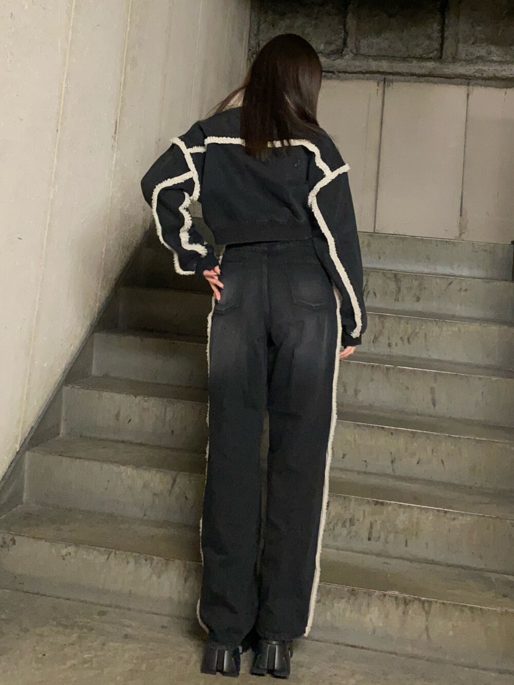 ブラック系のブルゾン、ブラック系のデニムパンツ、ブラック系のブーツを着用したレディースの秋コーディネートの3枚目の写真