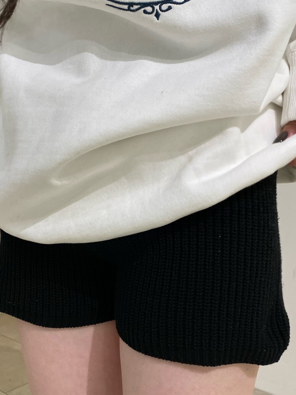 ホワイト系のスウェット、ブラック系のその他パンツ、ブラック系のブーツを着用したレディースの秋コーディネートの6枚目の写真