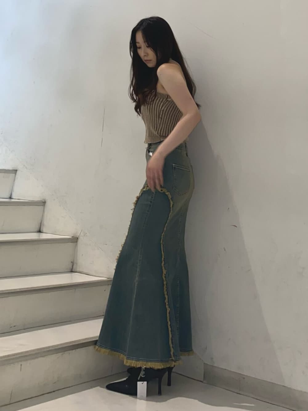 ブラック系のサンダル、ブルー系のデニムスカート、ブラウン系のニット/セーターを着用したレディースの夏コーディネートの2枚目の写真