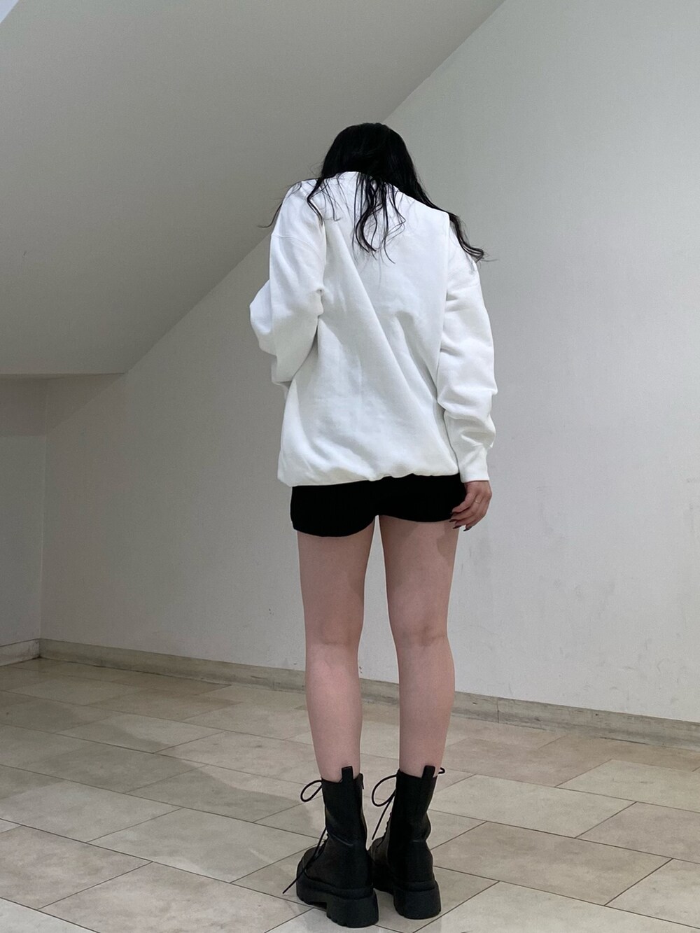 ホワイト系のスウェット、ブラック系のその他パンツ、ブラック系のブーツを着用したレディースの秋コーディネートの2枚目の写真