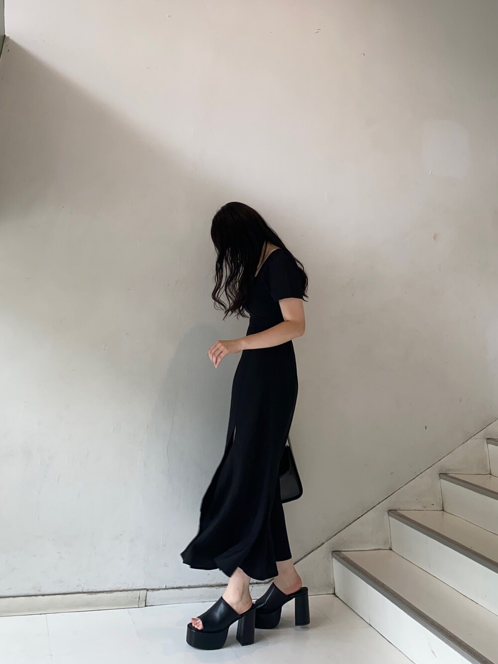 ブラック系のワンピース、ブラック系のサンダル、ブラック系のハンドバッグを着用したレディースの夏コーディネートの3枚目の写真