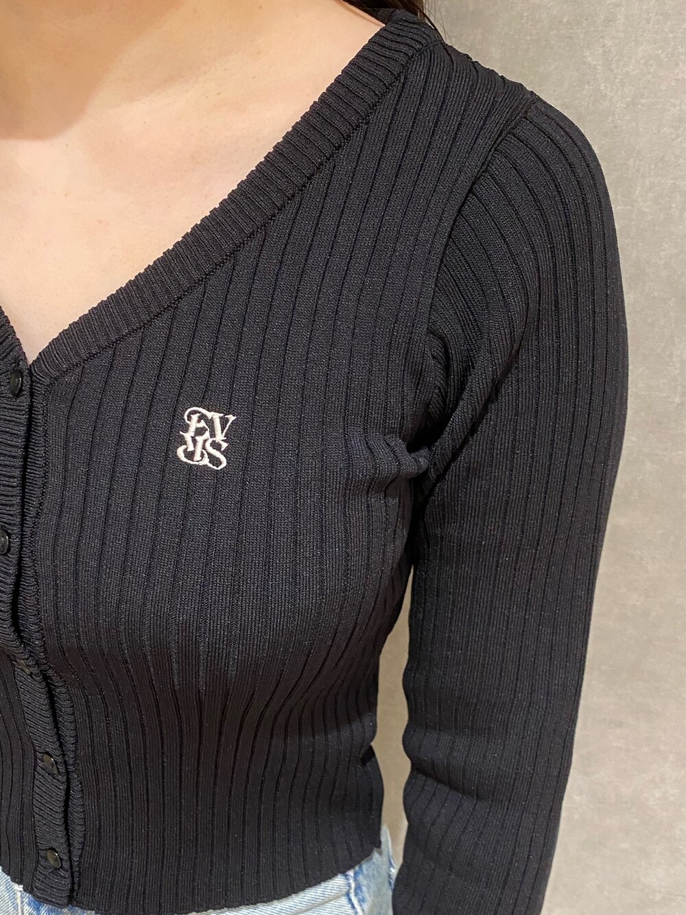 ブラック系のカーディガン/ボレロ、ブルー系のデニムパンツ、ブラック系のブーツを着用したレディースの秋コーディネートの4枚目の写真