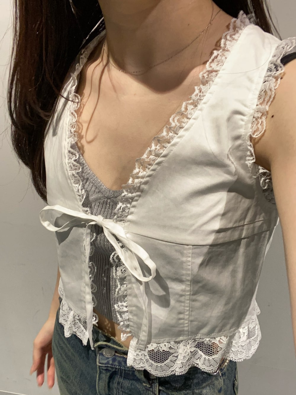 ブルー系のデニムパンツ、ホワイト系のサンダル、ホワイト系のシャツ/ブラウスを着用したレディースの夏コーディネートの4枚目の写真