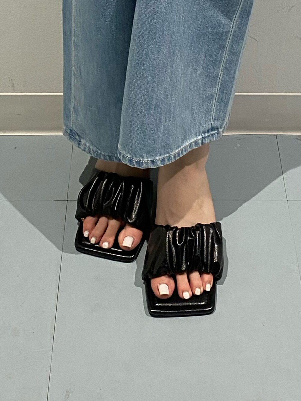 ホワイト系のTシャツ/カットソー、ブルー系のデニムパンツ、ブラック系のサンダルを着用したレディースの夏コーディネートの6枚目の写真