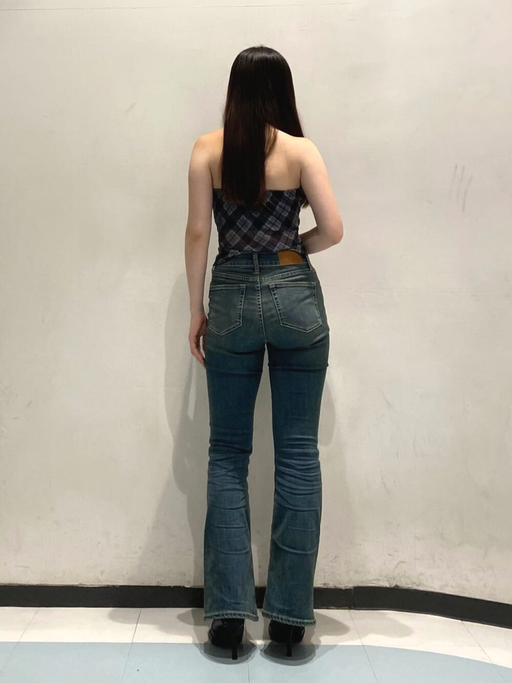 ブラック系のキャミソール、ブルー系のデニムパンツ、ブラック系のサンダルを着用したレディースの夏コーディネートの3枚目の写真